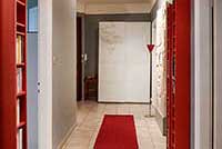 Couloir mis en valeur par un long tapis rouge et des bibliothèques de part et d'autre