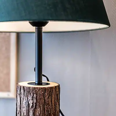 La lampe de bureau a un pied en bois avec son écorce.