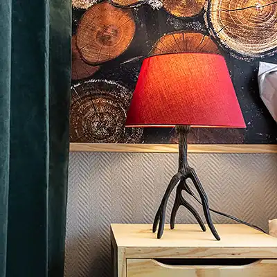 Lampe de chevet composée d'un pied en métal noir reprenant les formes d'un bois de cerf.