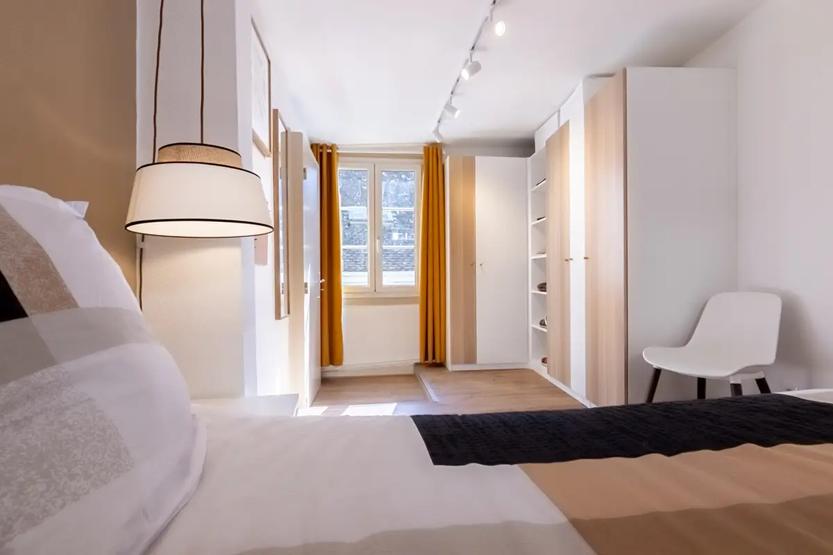 Lit avec vue sur armoire et fenêtre.