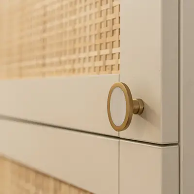 Porte de meuble avec bouton blanc et or, et osier