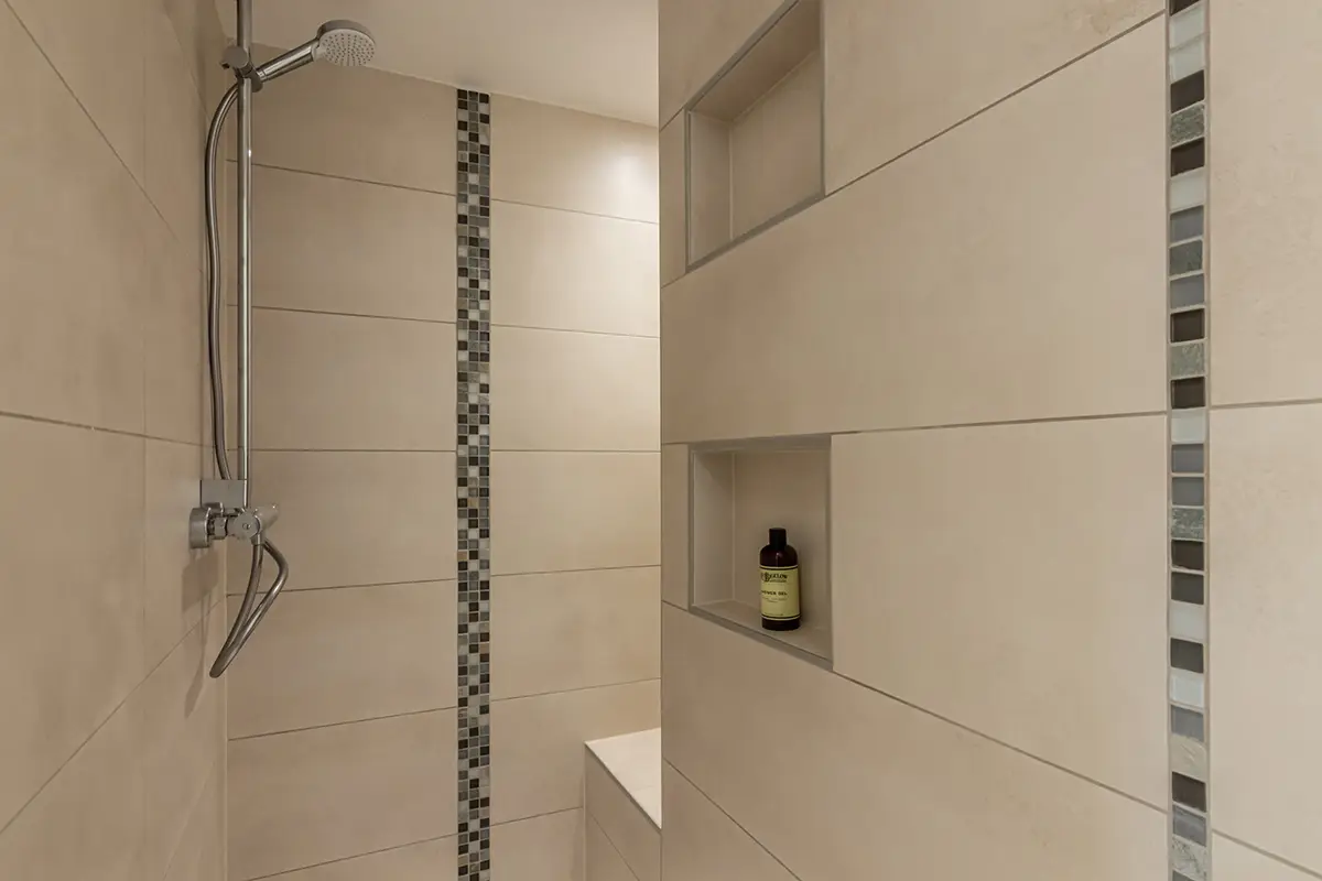 Douche carrelée avec un coin pour s'asseoir.